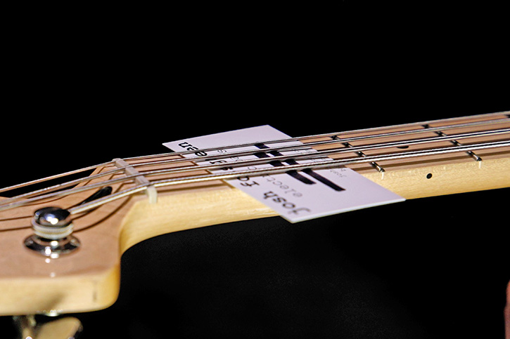 Picture of a bass with a business card under the strings