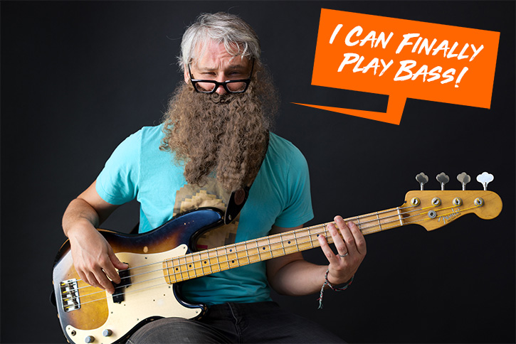 Gio with a bushy beard holding a bass and a speech bubble above his head saying "I can finally play bass"